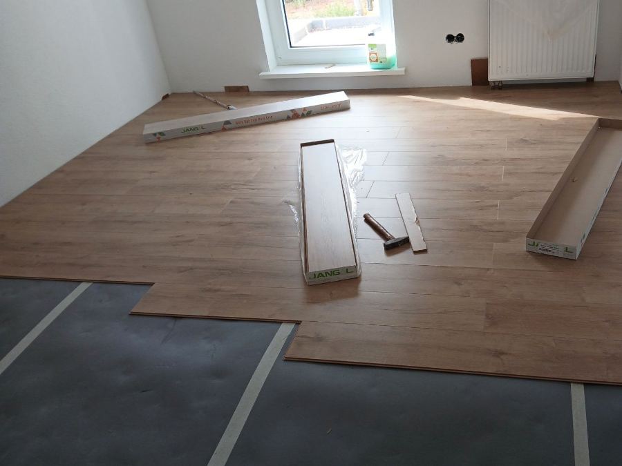 Zur Hälfte verlegter Laminatboden in einem hellen Wohnraum in Wetter (Hessen).